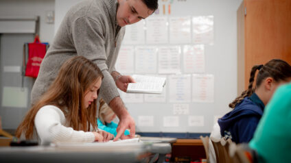 Teacher helping a student in classroom